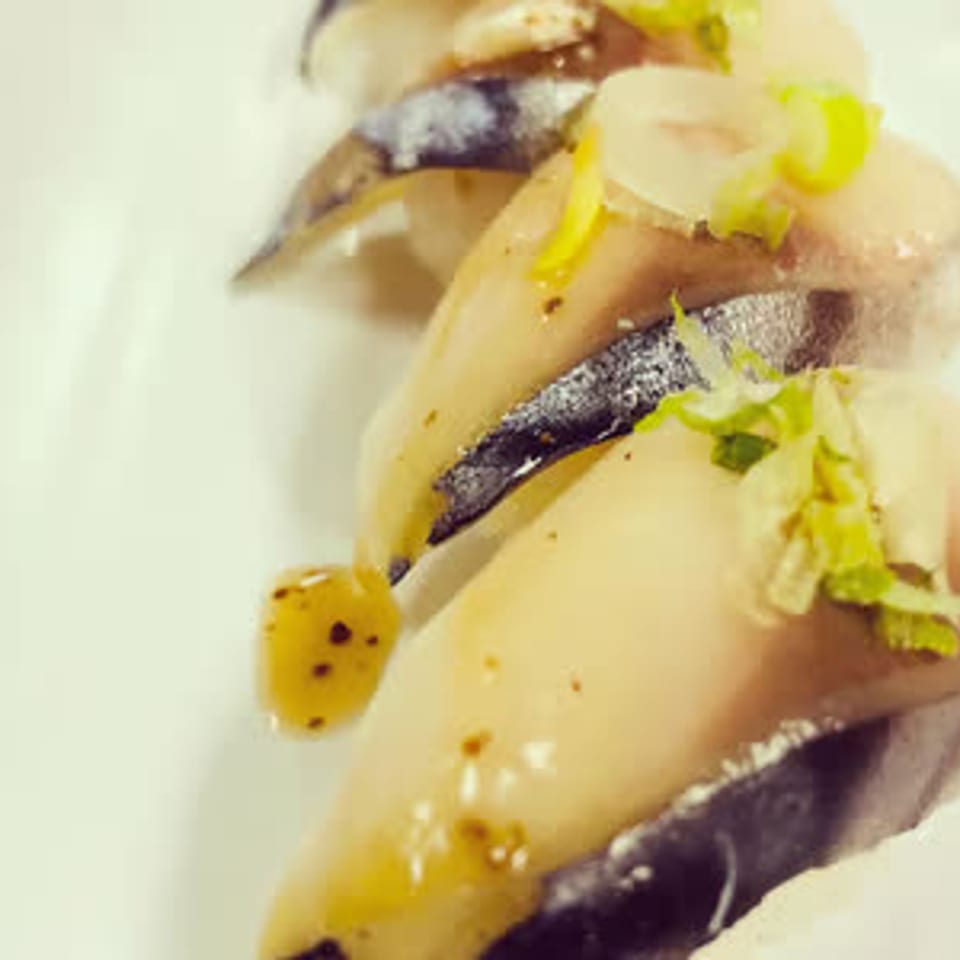 Close-up of sushi topped with fish and sliced scallions